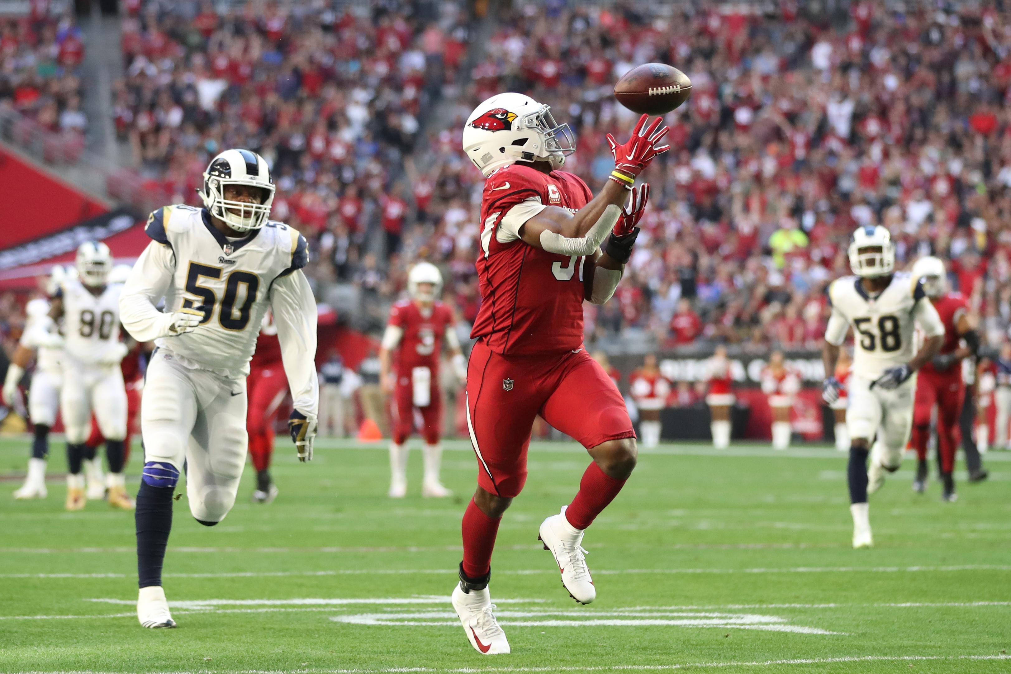 GLENDALE, ARIZONA - DECEMBER 23: David Johnson #31 of the Arizona Cardinals catches a 32 yard touchdown pass from wide receiver Larry Fitzgerald #11 in the first half of the NFL game against the Los Angeles Rams at State Farm Stadium on December 23, 2018 in Glendale, Arizona. (Photo by Christian Petersen/Getty Images)
