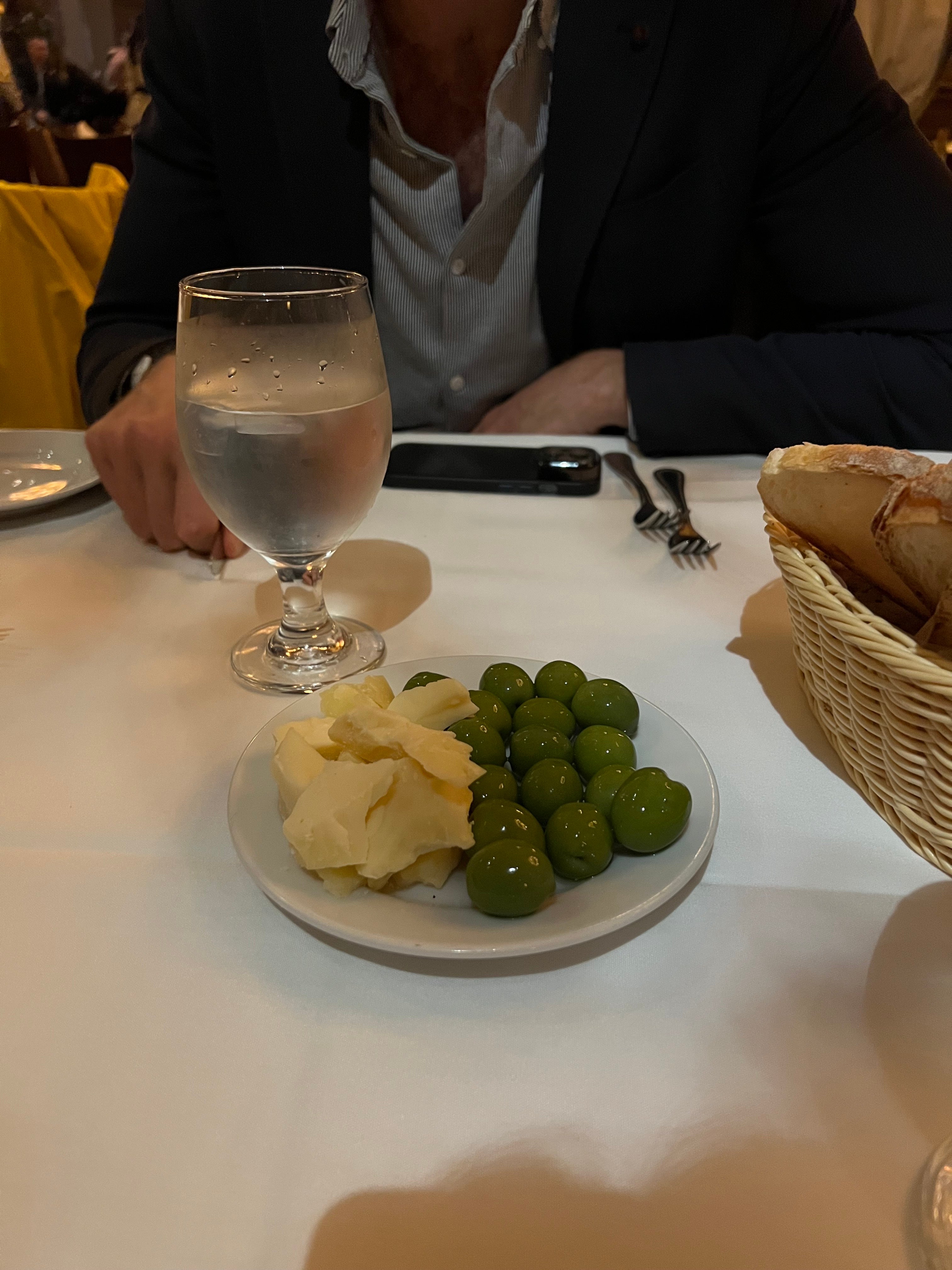A plate of green olives and cheese.