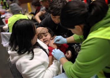 A young girl receives a band aid after getting an H1N1 flu vaccination, December 2009 in San Francisco, California. 