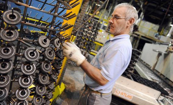 An employee prepares parts of automatic gearboxes.