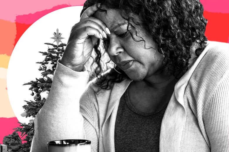 Woman bowing her head, looking upset, with a Christmas tree in the background