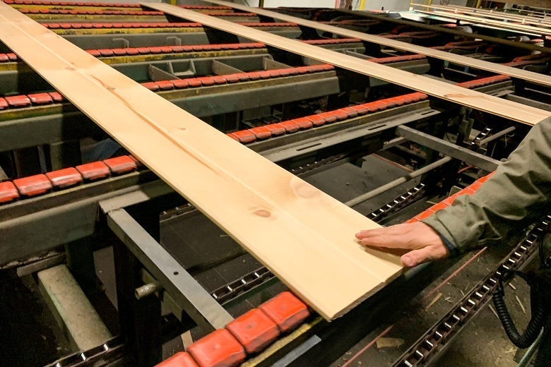 A finished board comes off the line at Robbins Lumber.