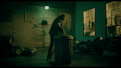 A gif of David Harbour getting into a trash can.