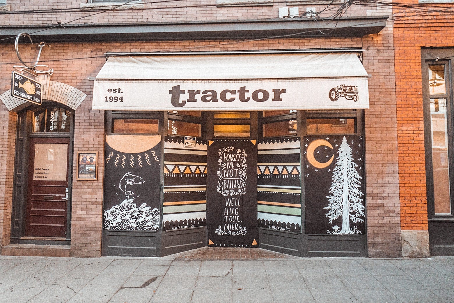 A mural featuring trees, fish, and more beneath an awning that says "Tractor."