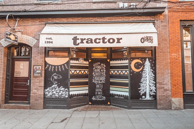 A mural featuring trees, fish, and more beneath an awning that says "Tractor."