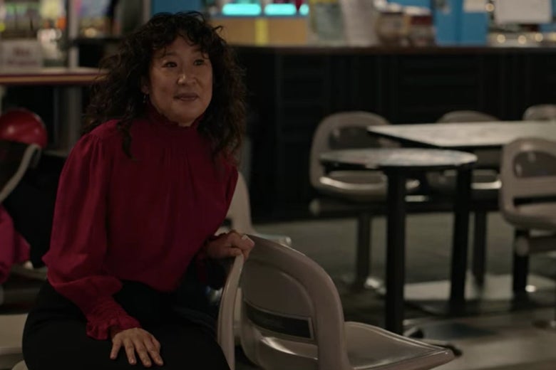 Dr. Kim sits on a plastic seat at a bowling alley.