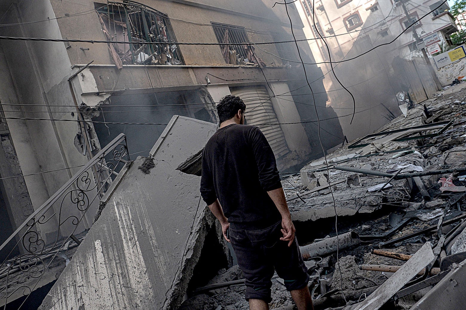 A man walks amongst the aftermath of targeting Al-Jawhara Tower in central Gaza on Wednesday in Gaza City.