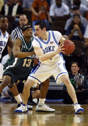 J.J. Redick #4 of the Duke Blue Devils handles the ball under pressure from Maurice Ager #13 of the Michigan State Spartans.