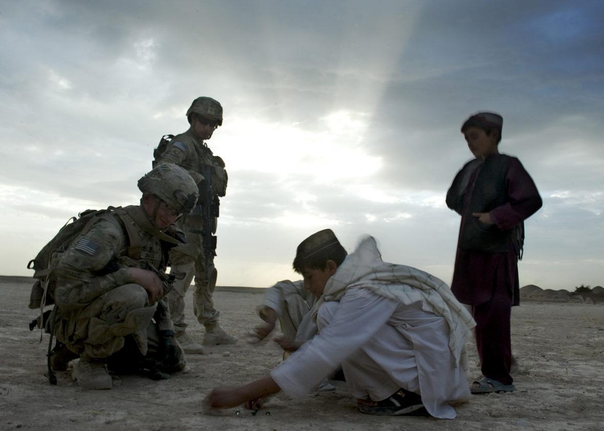 US soldiers from the 1st Platoon, 1-64 Armored Batallion of the US Army, operating under NATO command, interact with Afghan boys