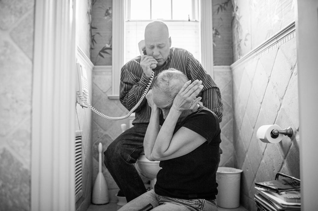 Howie and Laurel Borowick sit next to the bathroom telephone as they hear the most recent news from their oncologist- good scans for both of them, and their respective tumors are shrinking. Chappaqua, New York. March 2013.