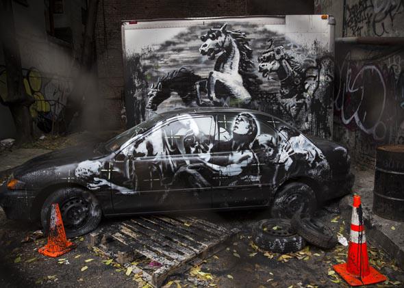 The latest work from street artist Banksy is seen through a chain link fence on October 9, 2013 in the Lower East Side neighborhood of New York City. 