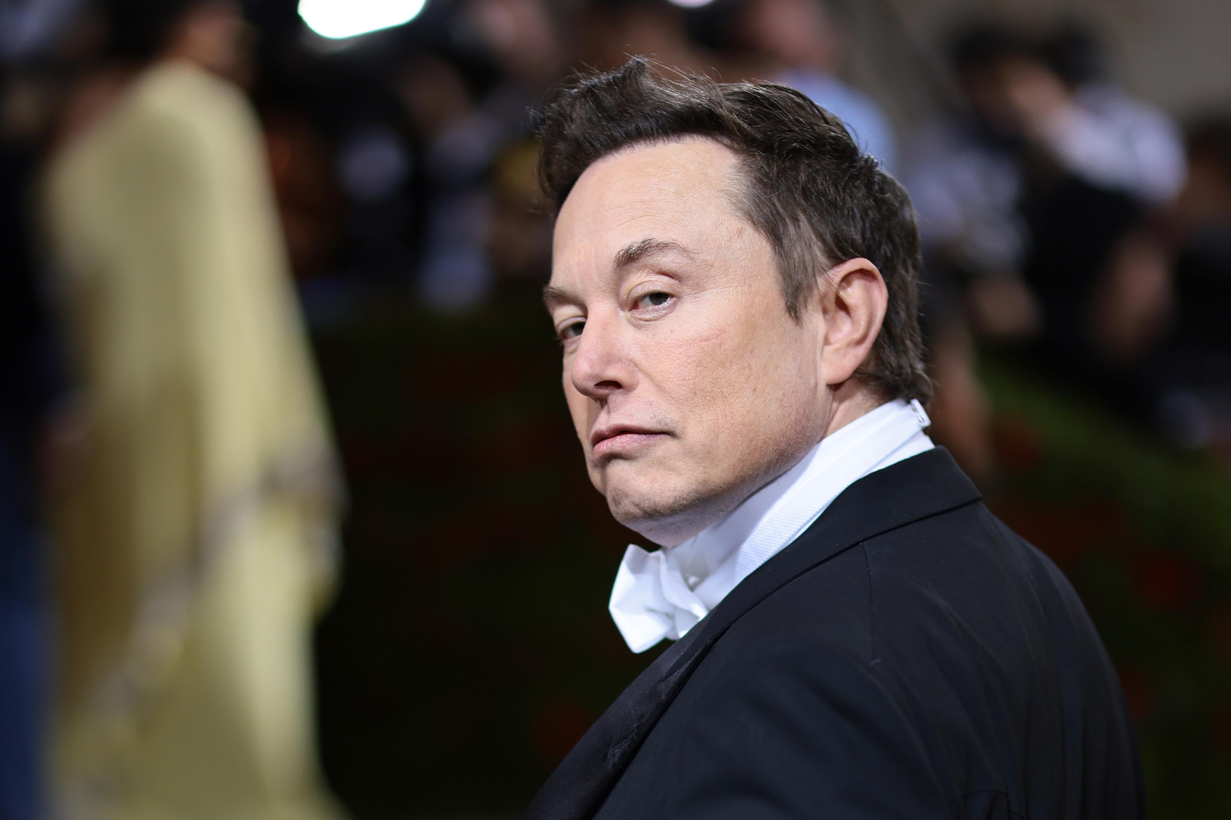 Musk mugging in a tux on the red carpet