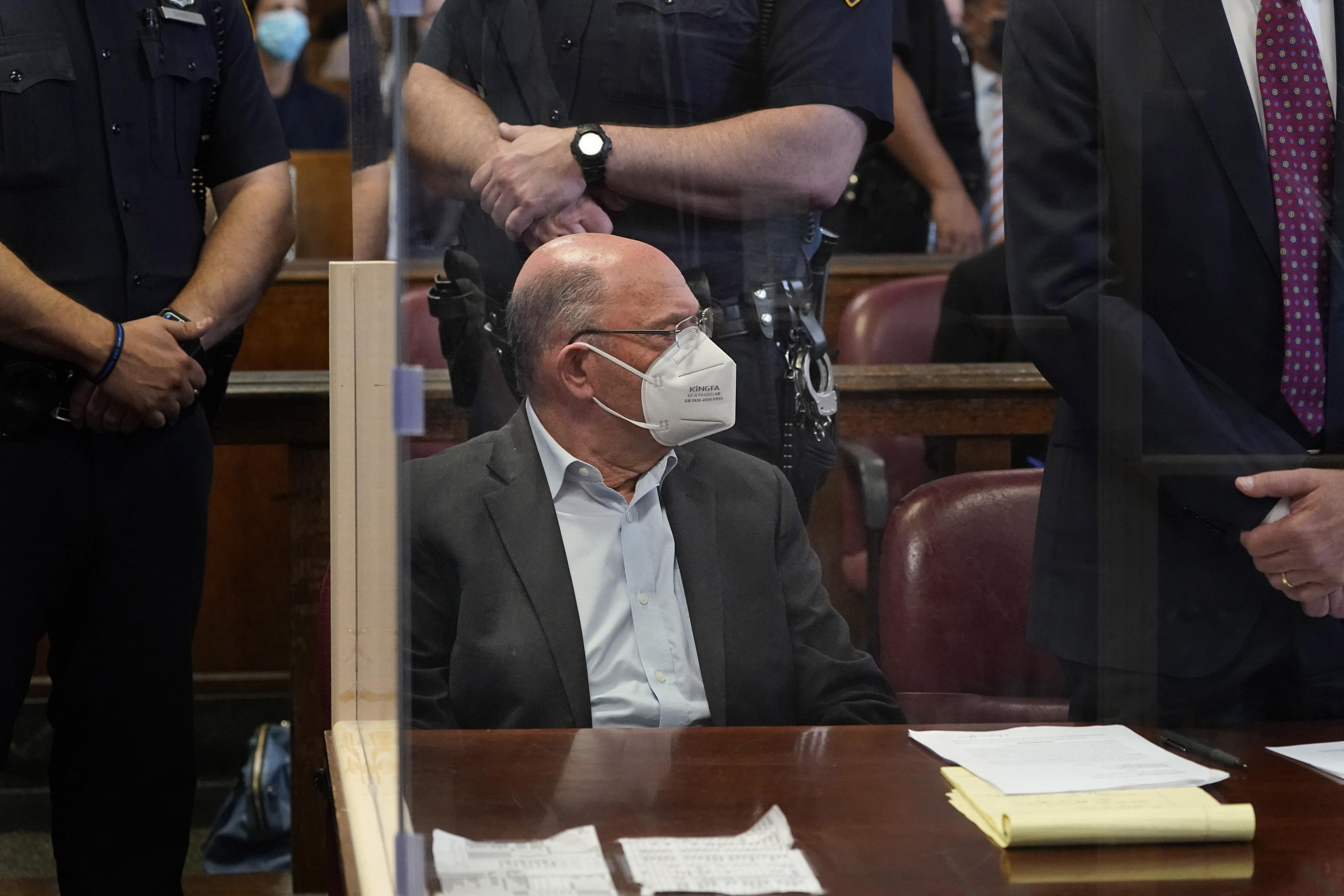 Weisselberg wears a mask and a gray suit, sitting in the courtroom.