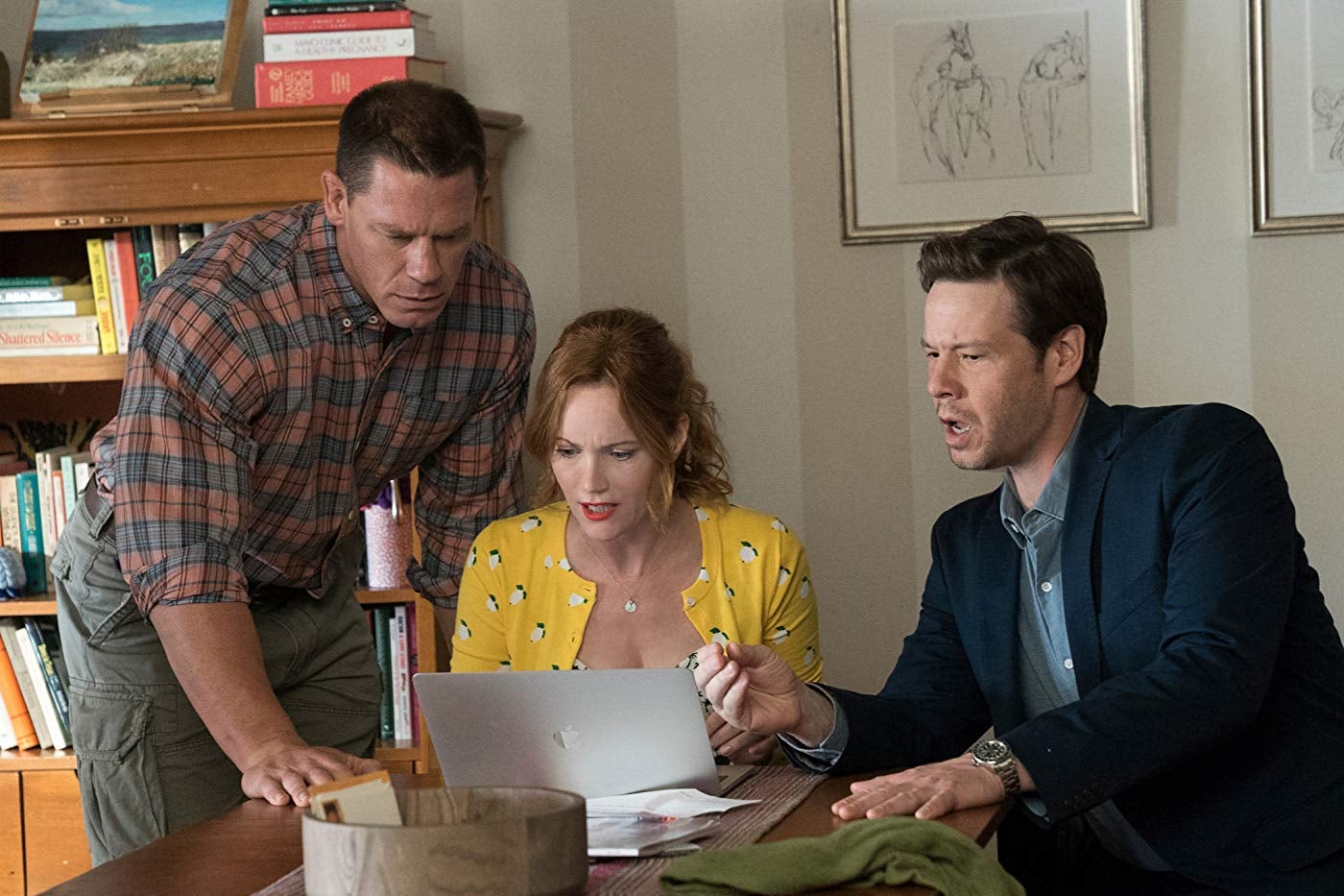 Leslie Mann, Ike Barinholtz, and John Cena huddle around a laptop.
