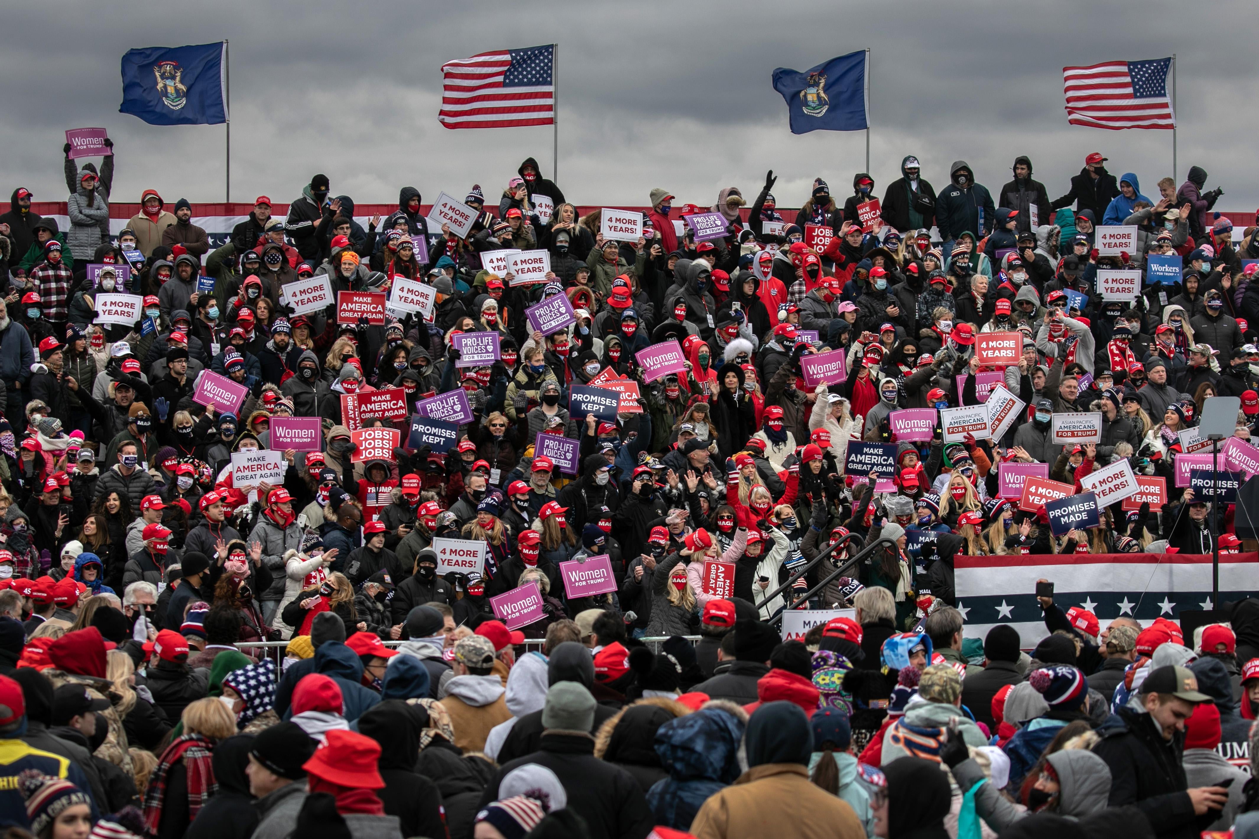 Supporters of President Donald Trump cheer at a campaign rally at Oakland County International Airport on October 30, 2020 in Waterford, Michigan. 