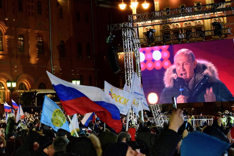 People listen to President Vladimir Putin during a rally and a concert celebrating the fourth anniversary of Russia's annexation of Crimea at Manezhnaya Square in Moscow on March 18, 2018.