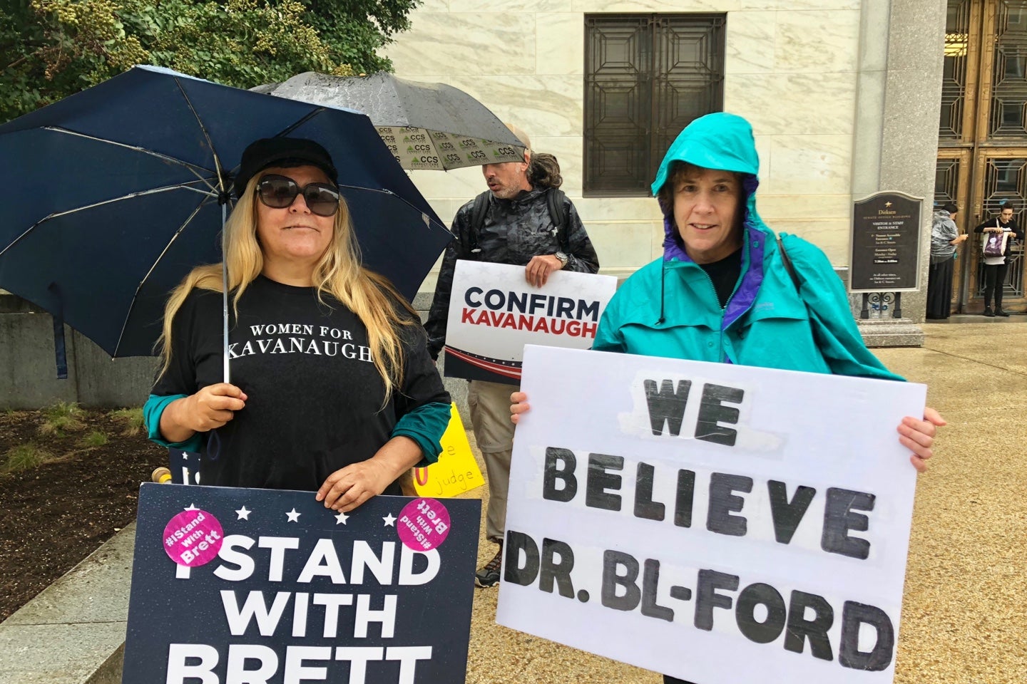 Lourdes Washington (left) and Abby Bolt (right) holding up signs with opposing views in front of the Dirksen Senate Office Building, where the hearing was held. Washington supported Kavanaugh and Bolt supported Ford.