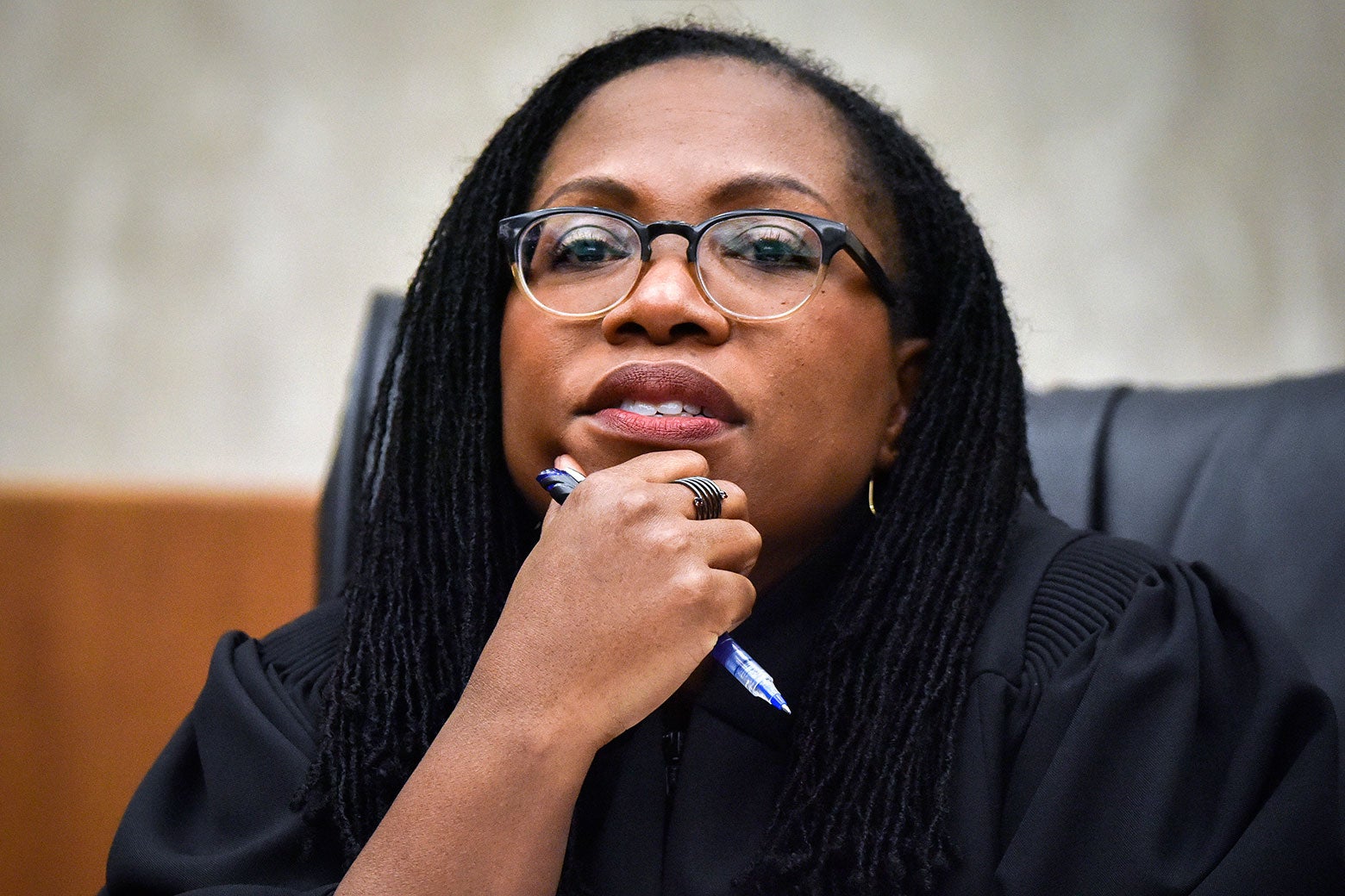 Justice Jackson holds her hand to her chin and a pen.