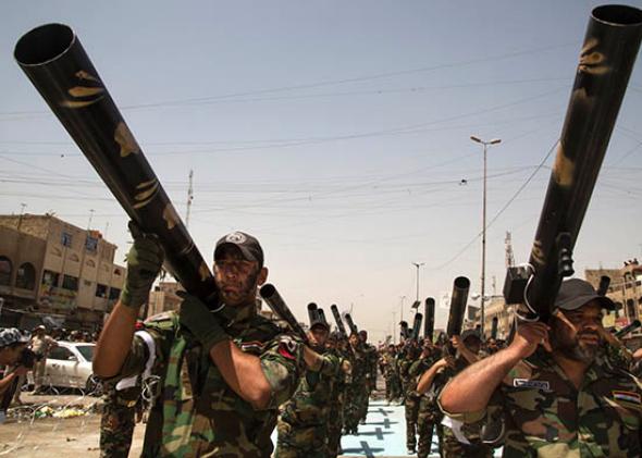 Units of Moqtada Sadr's militia parade down a main street of the Shi'a stronghold of Sadr City June 21, 2014, in Eastern Baghdad. 