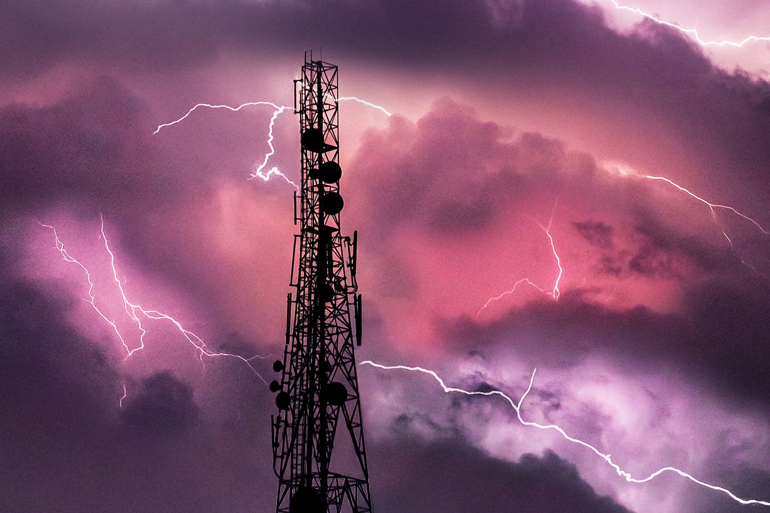 Lightning in a stormy sky, around a radio tower. 