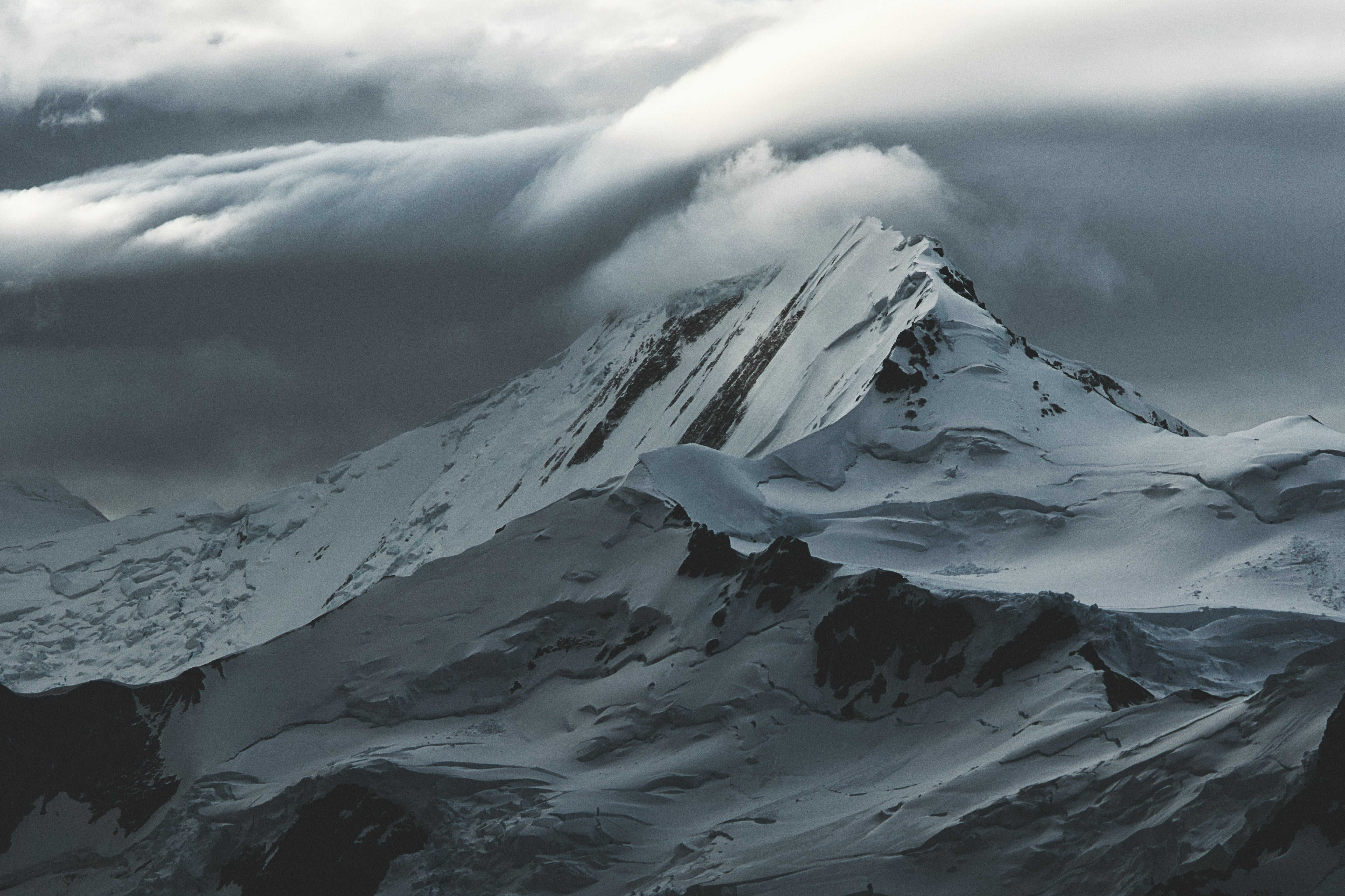 A snow-covered mountain under cloudy skies.