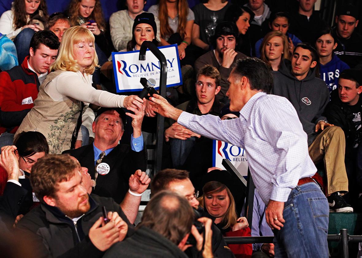 Republican presidential candidate, former Massachusetts Gov. Mitt Romney takes back a microphone from a woman who asked a question during a campaign town hall meeting at Central High School January 4, 2012 in Manchester, New Hampshire. 