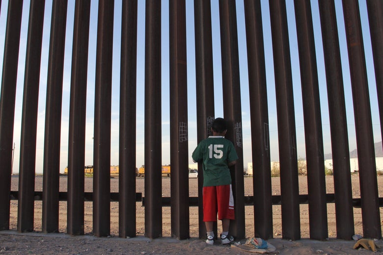 A Mexican child looks at a vehicle of the US border patrol through the US-Mexico fence in Ciudad Juarez, Chihuahua state, Mexico on April 4, 2018. 