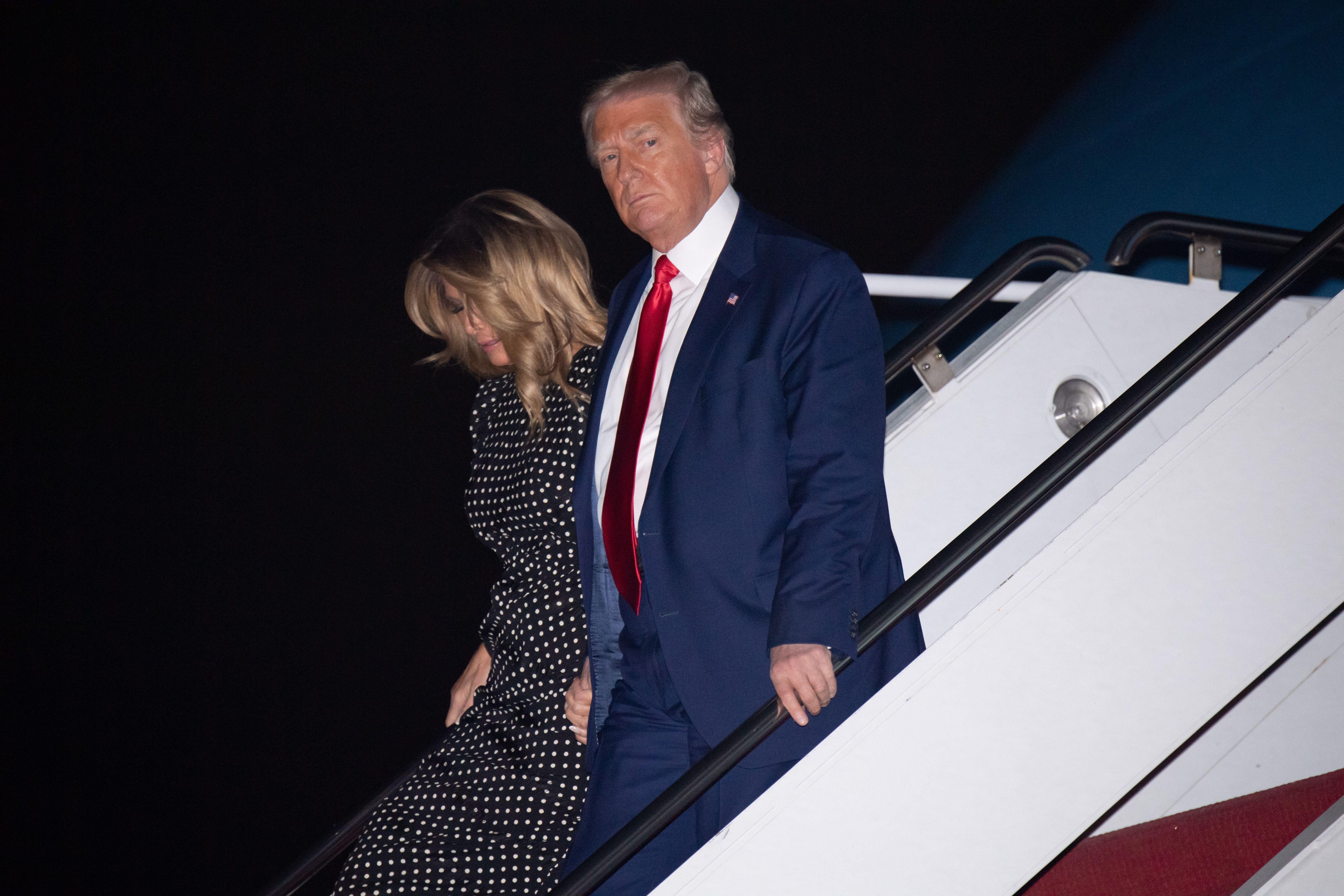Donald Trump and Melania Trump disembark from Air Force One at night