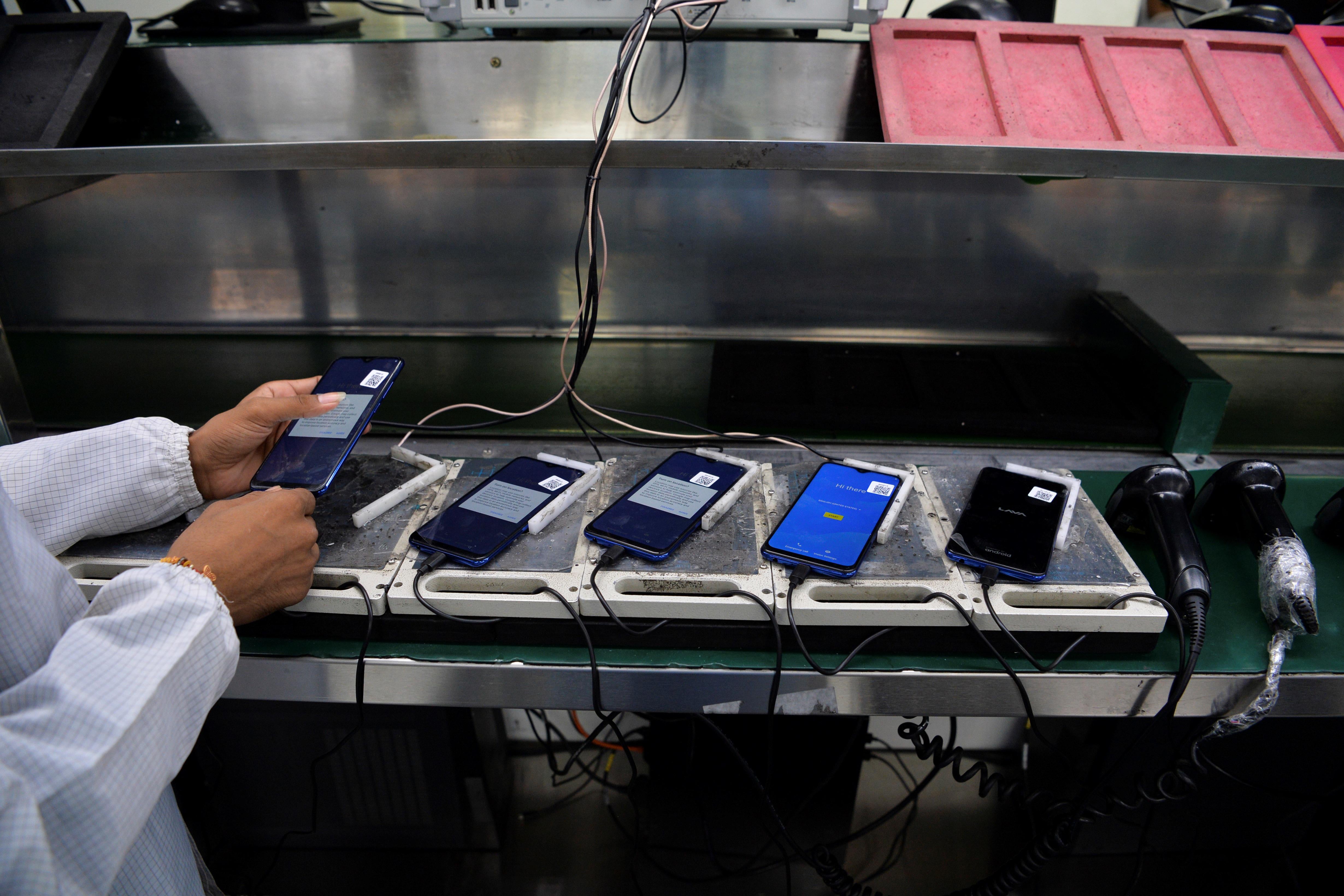 A worker assembles mobile phones at an Indian Lava phone manufacturer factory in Noida on August 22, 2019.