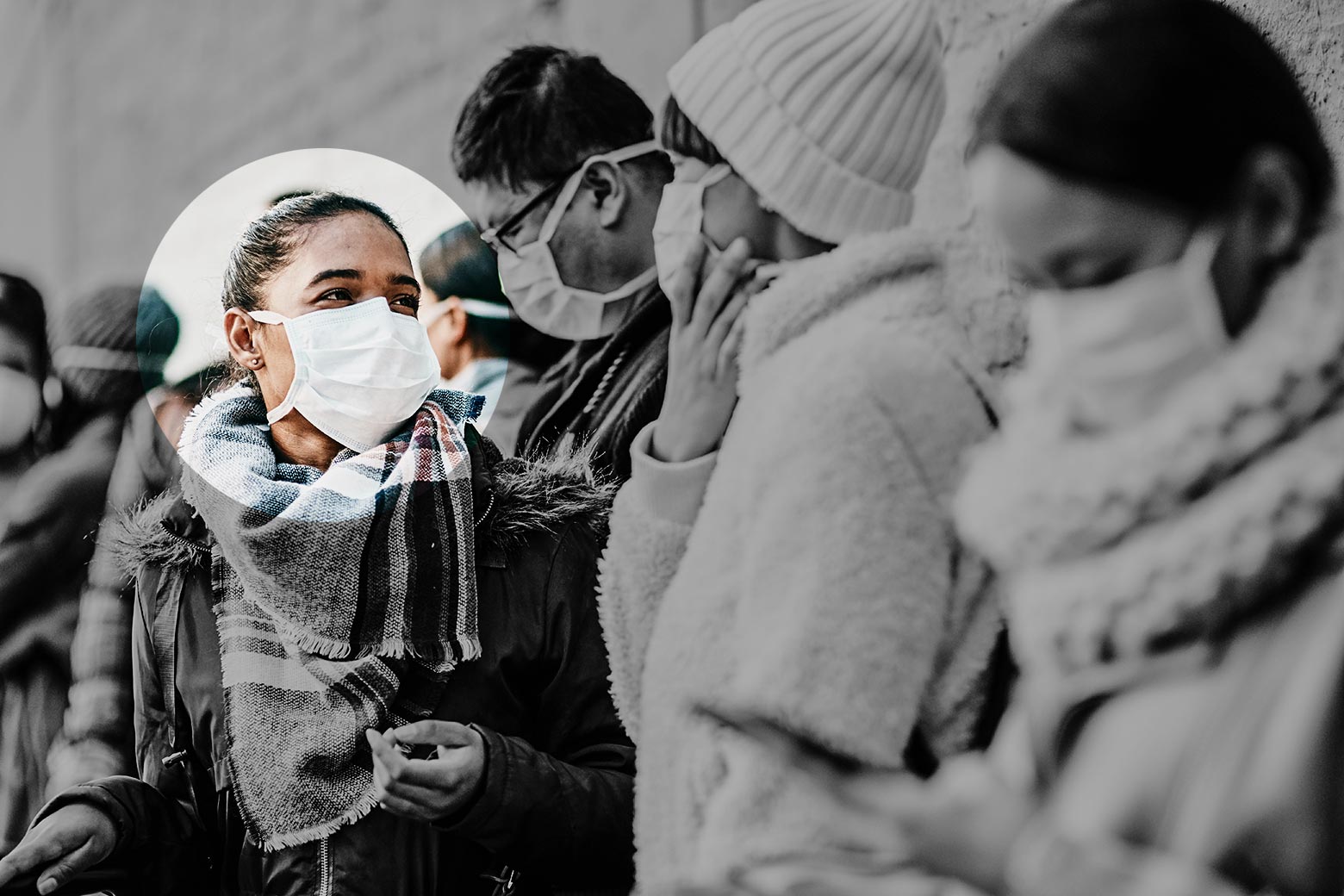 A woman with a mask on waiting in line. She is highlighted to show it's her turn.