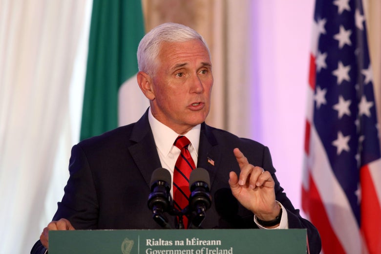 Vice President Mike Pence speaks while standing in front of Irish and American flags.