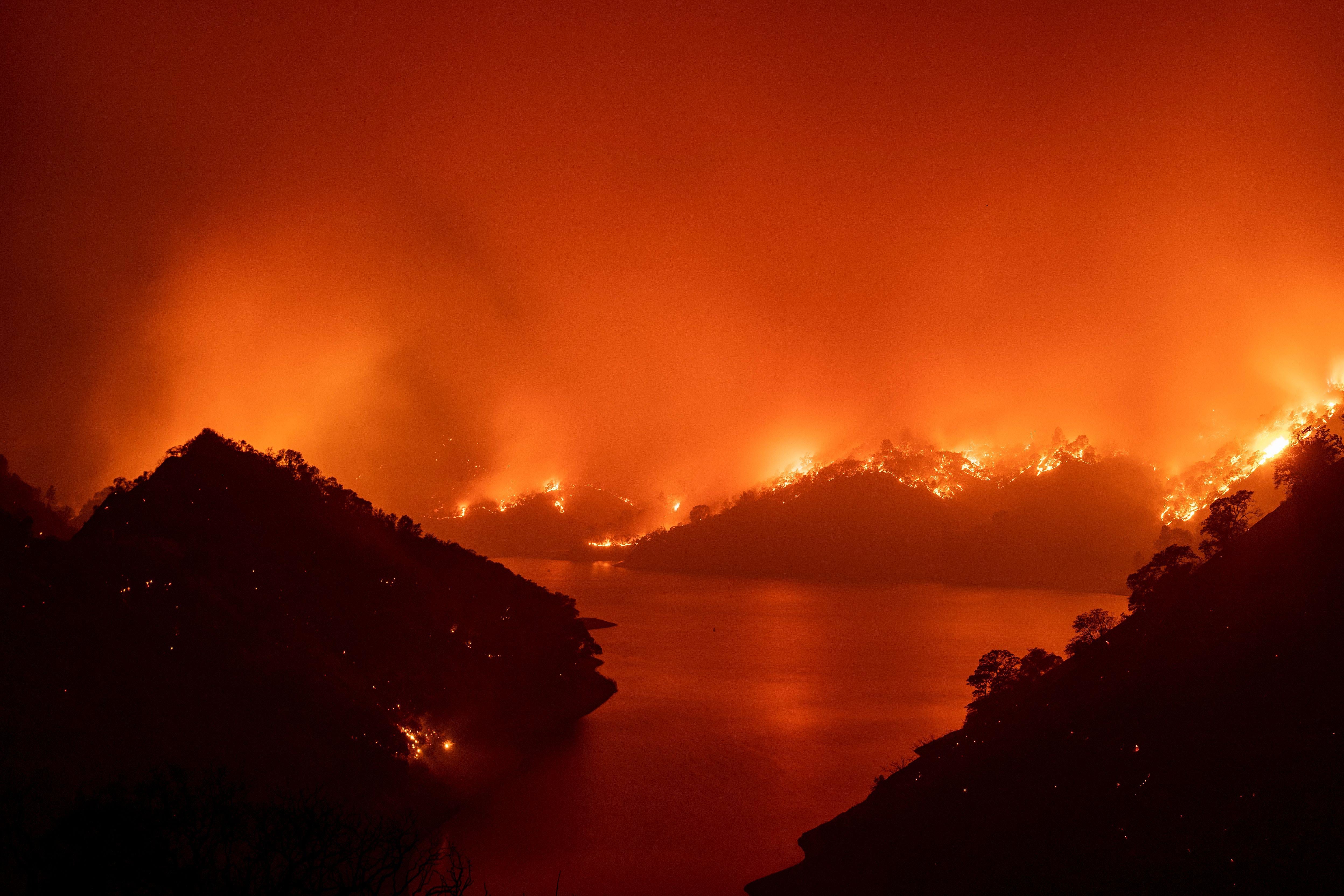 Flames surround Lake Berryessa during a wildfire.