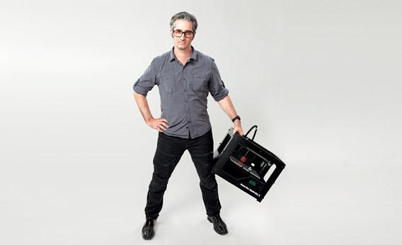 Bre Pettis holding a MakerBot Replicator 2 Desktop 3D printer.
