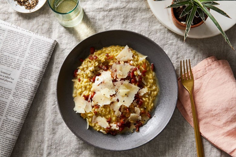 Golden brown risotto topped with shaved cheese and pomegranate seeds.