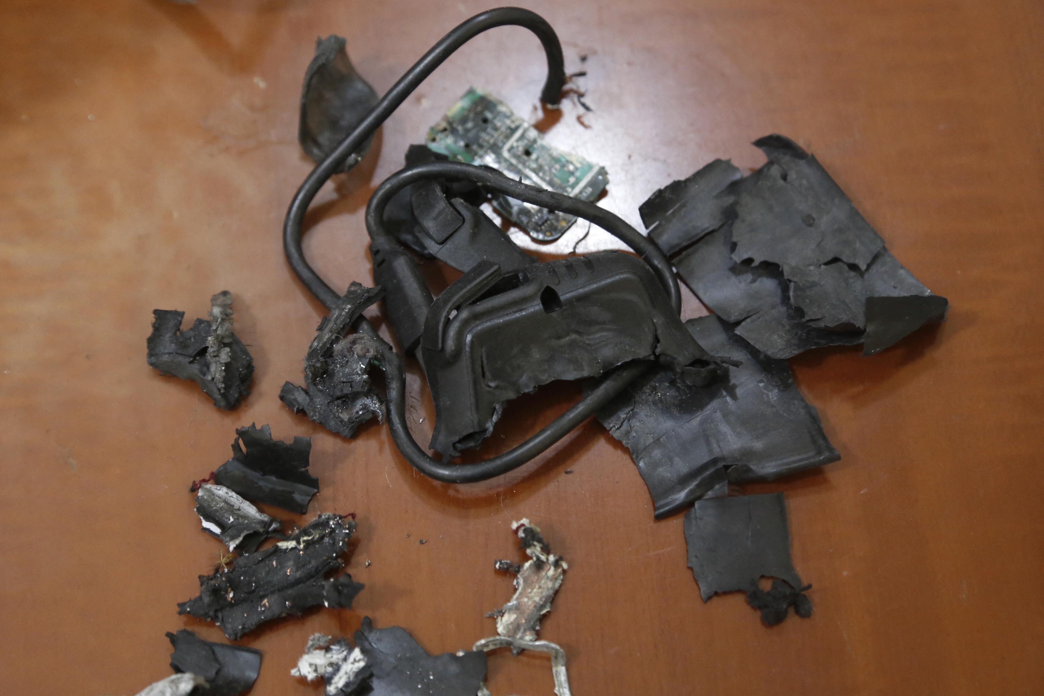 An exploded pager, with frazzled black wire and broken pieces of plastic.