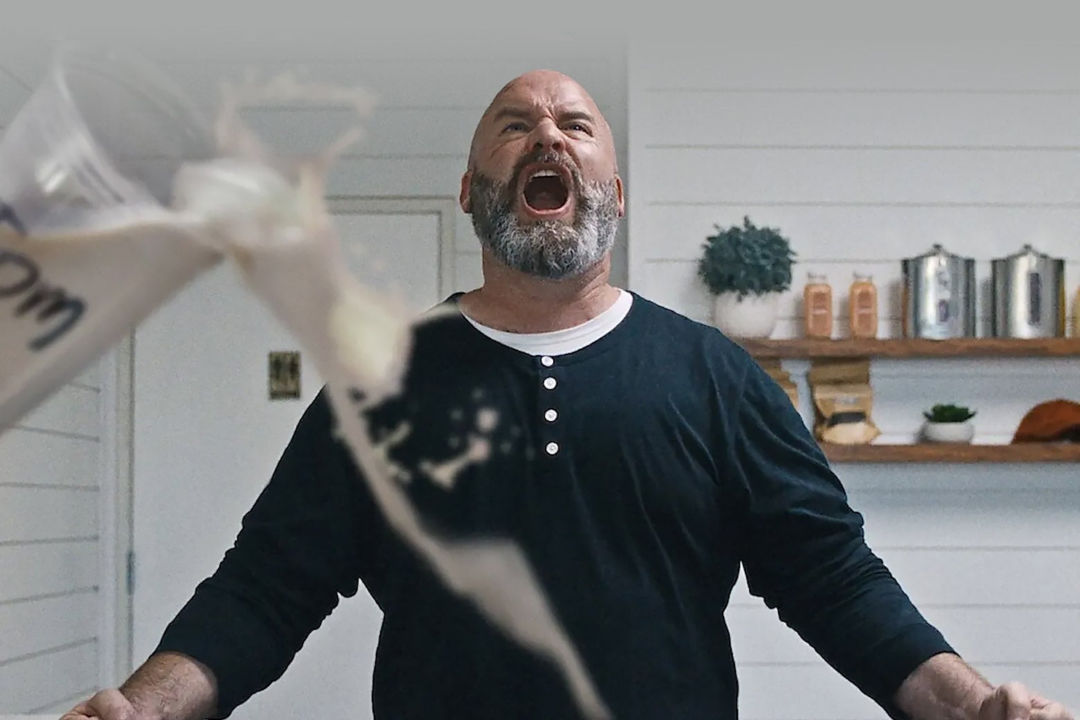 A middle-aged bald white guy screams and looks upward in frustration.