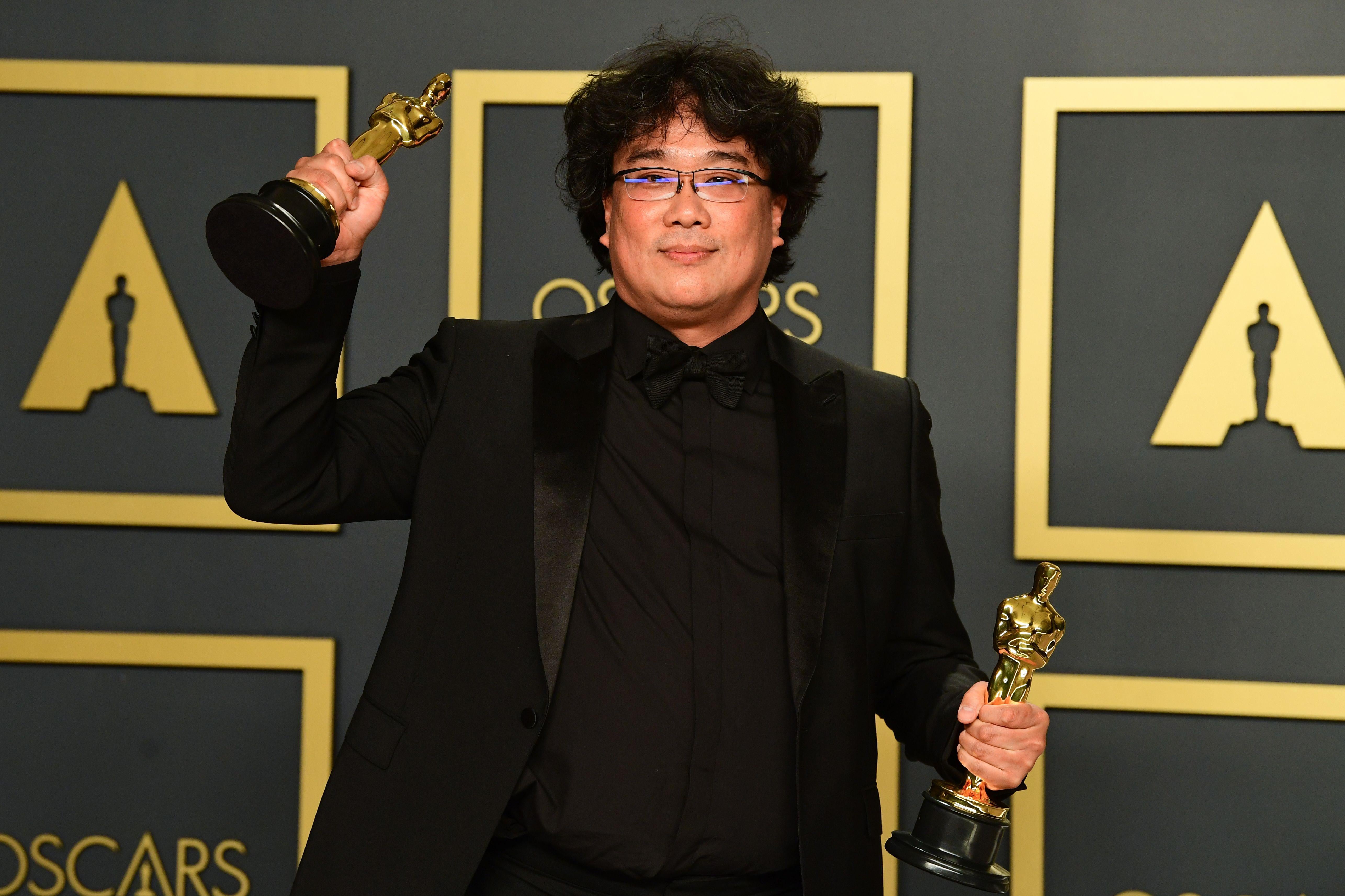 South Korean director Bong Joon-ho poses in the press room with his trophies.