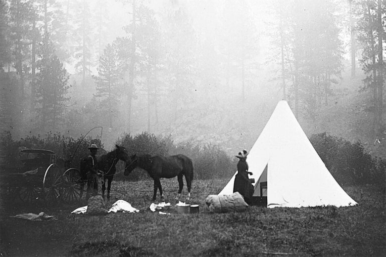 Fletcher's Sibley tent, just to the right center of this image, is pitched in a forest clearing dim with ambient smoke. 