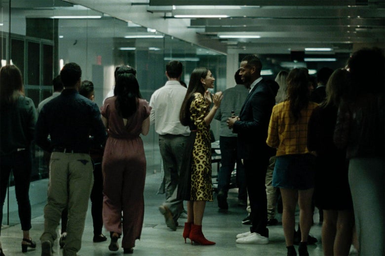 Marlon Wayans, wearing trendy sneakers, stands in a crowded hallway talking to a well-dressed woman