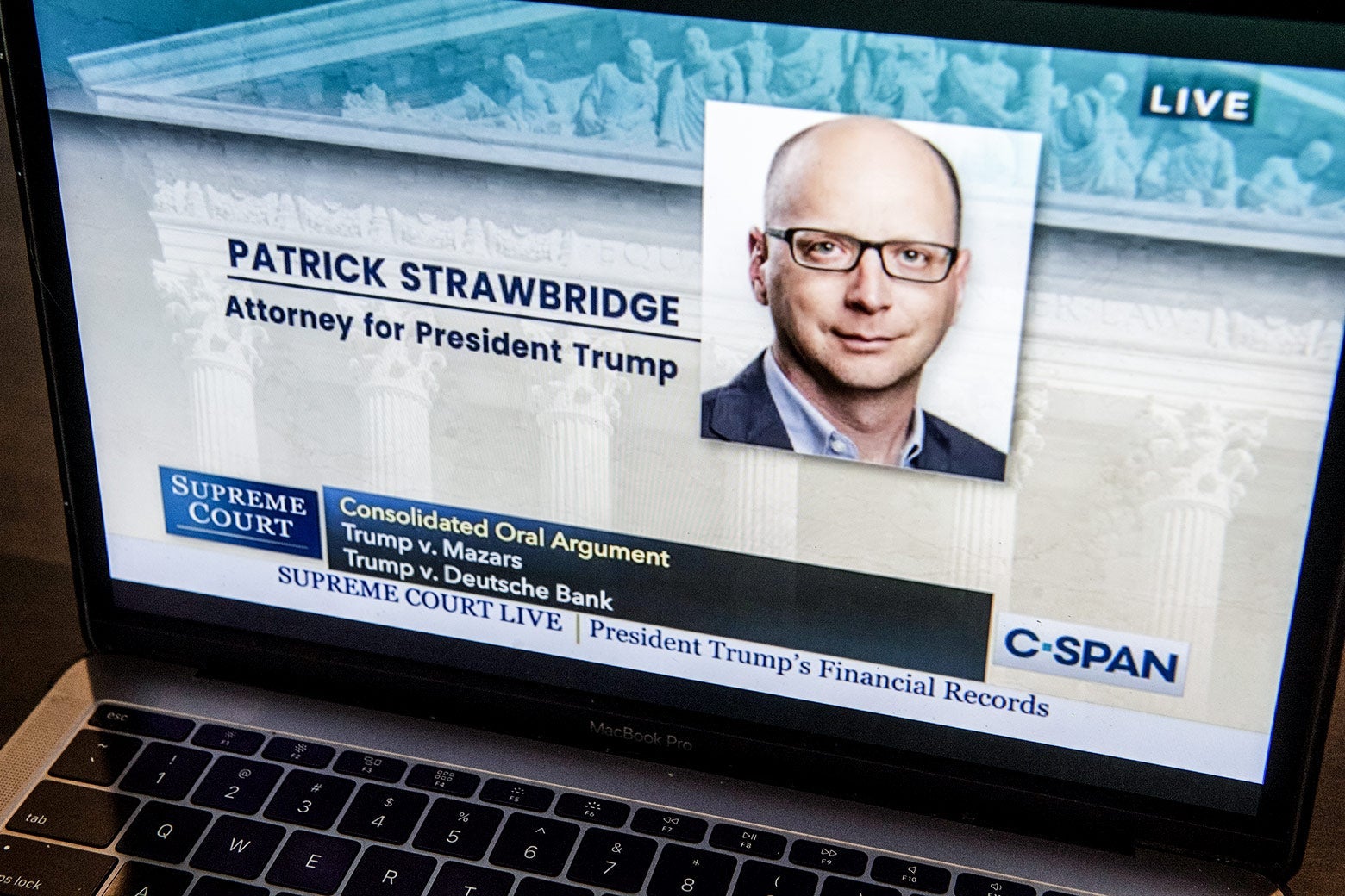 Laptop open to the Supreme Court livestream, with Strawbridge's photo on the screen