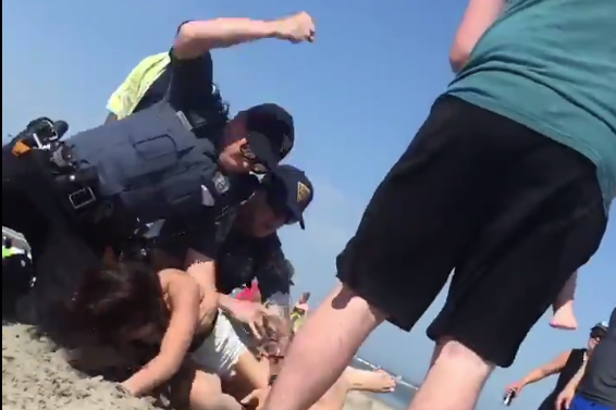 A screenshot from a video posted on Twitter shows the moment when a police officer raised his arm before punching 20-year-old Emily Weinman at a beach in Wildwood, New Jersey on May 26, 2018.