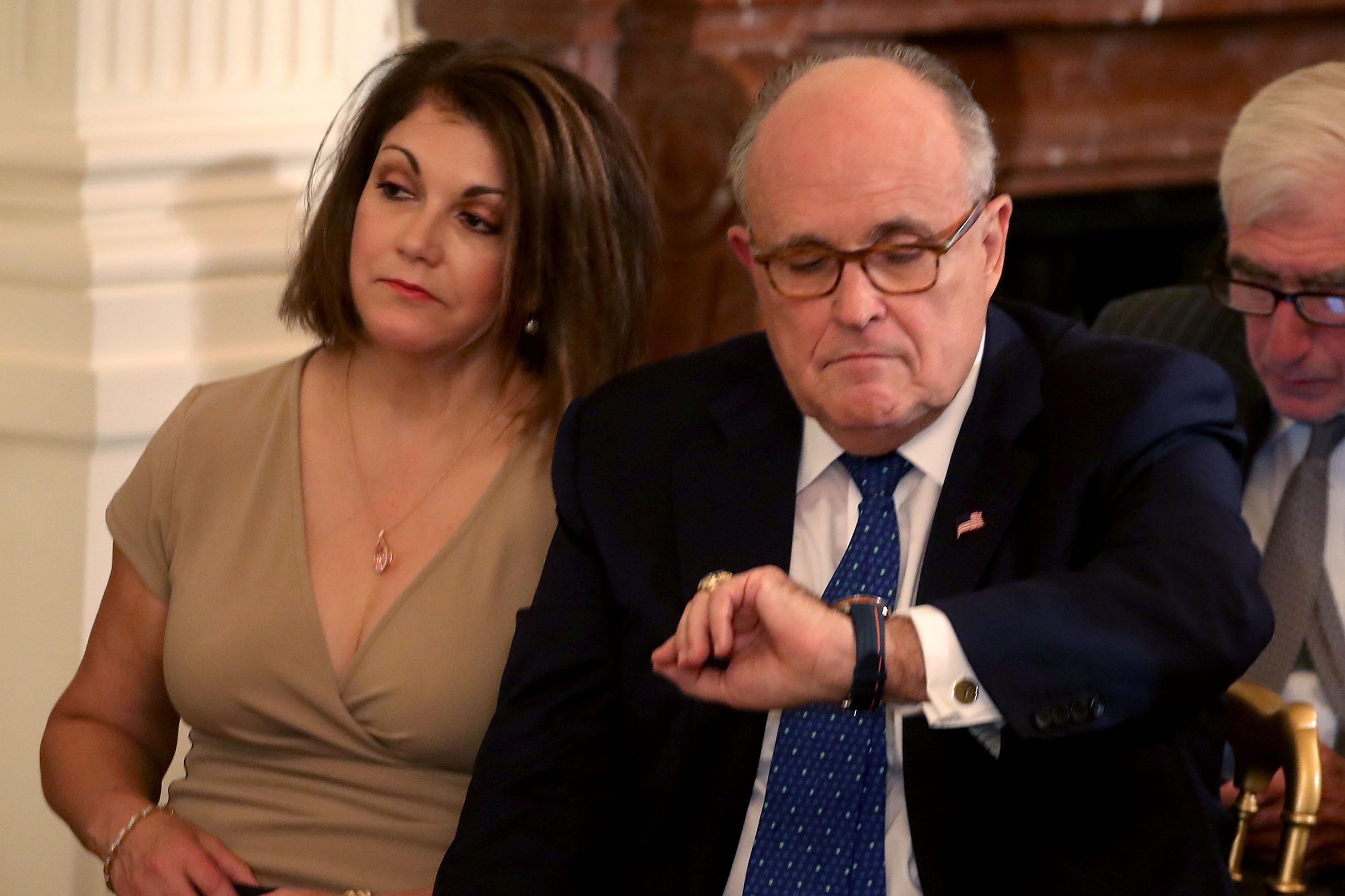 Rudy Giuliani looks at his watch.