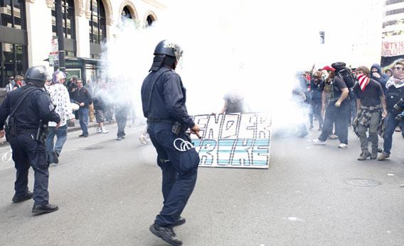 Oakland police officers fire tear gas to control a group of Occupy Wall Street protesters.