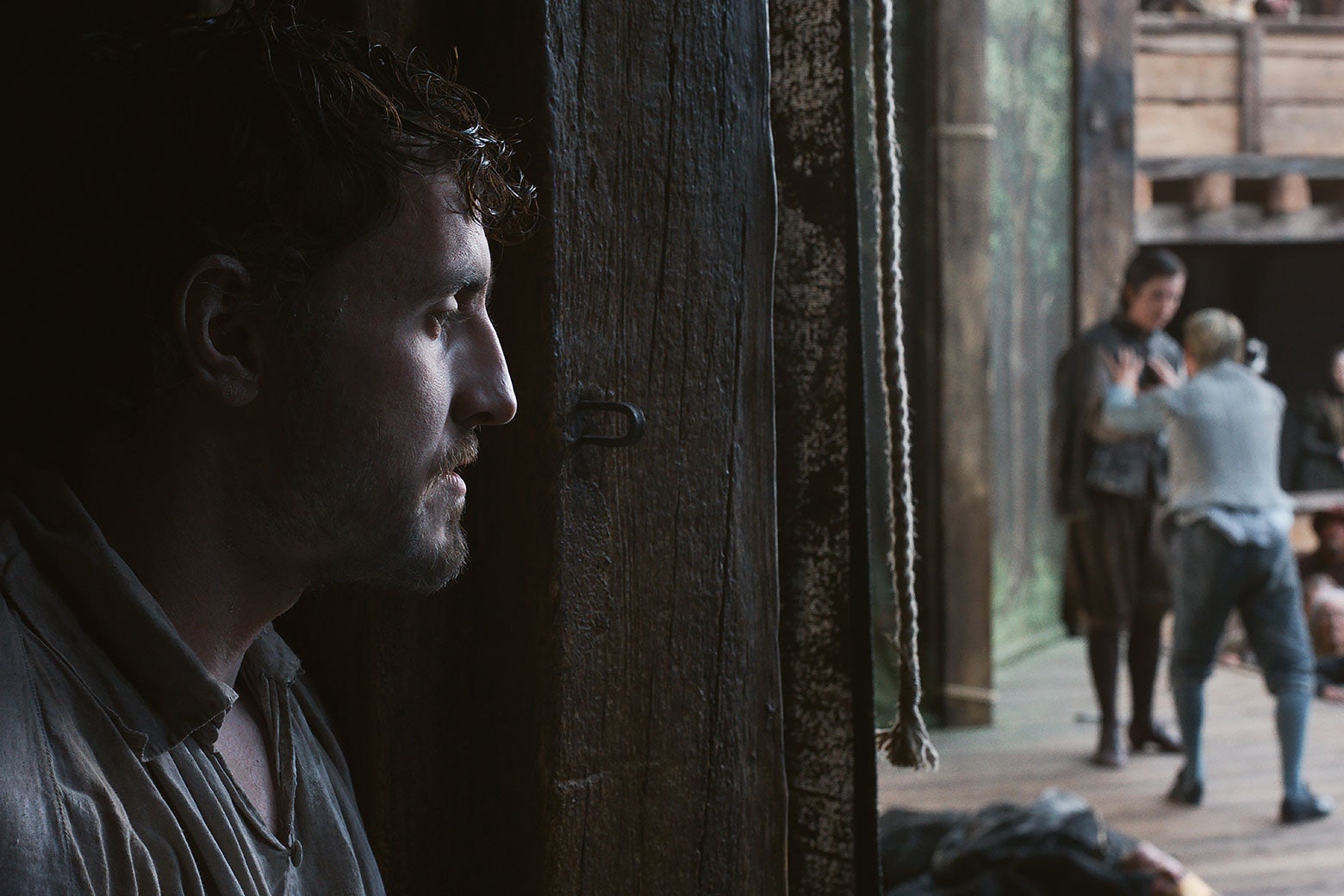 A young brown-haired man looking out at the stage during a play.
