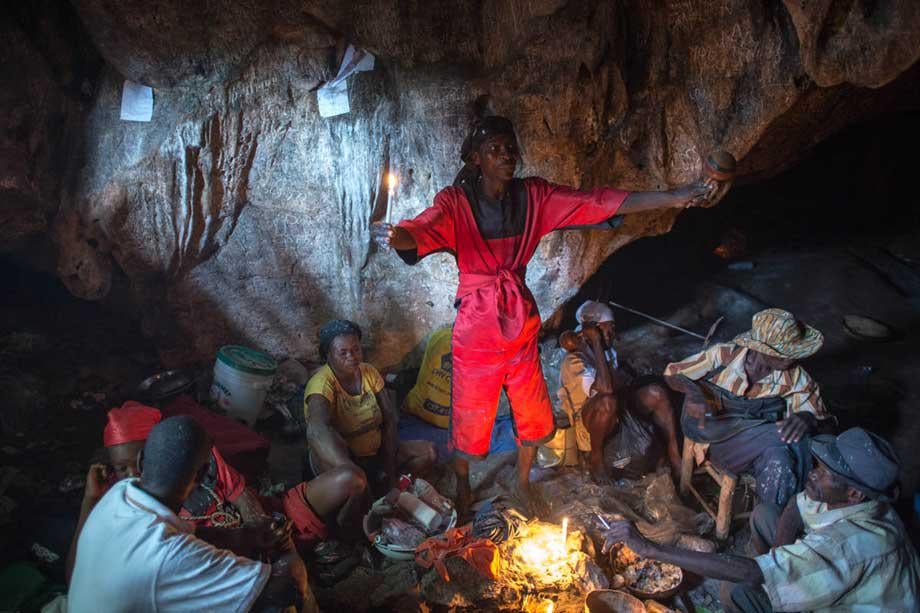 A Vodou priest (Hougan or Houngan) begins to invoke the spirits (Loa or Iwa) during the feast day of St. Francis De Assisi in a remote region of Haiti.