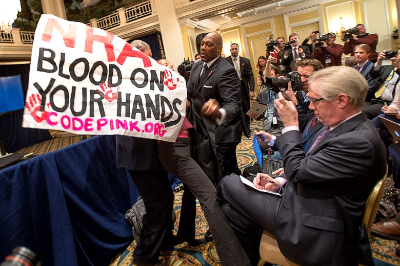 Code Pink activist Medea Benjamin is removed from an NRA press conference.