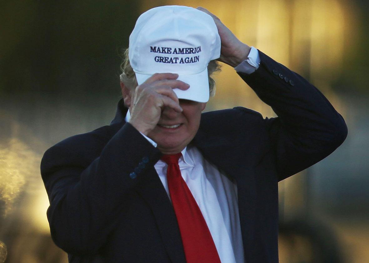 Republican presidential candidate Donald Trump adjusts his hat during a campaign rally at the Collier County Fairgrounds on October 23, 2016 in Naples, Florida. 