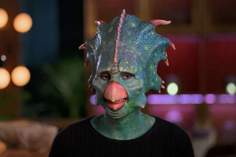 Woman dressed as a blue dinosaur.