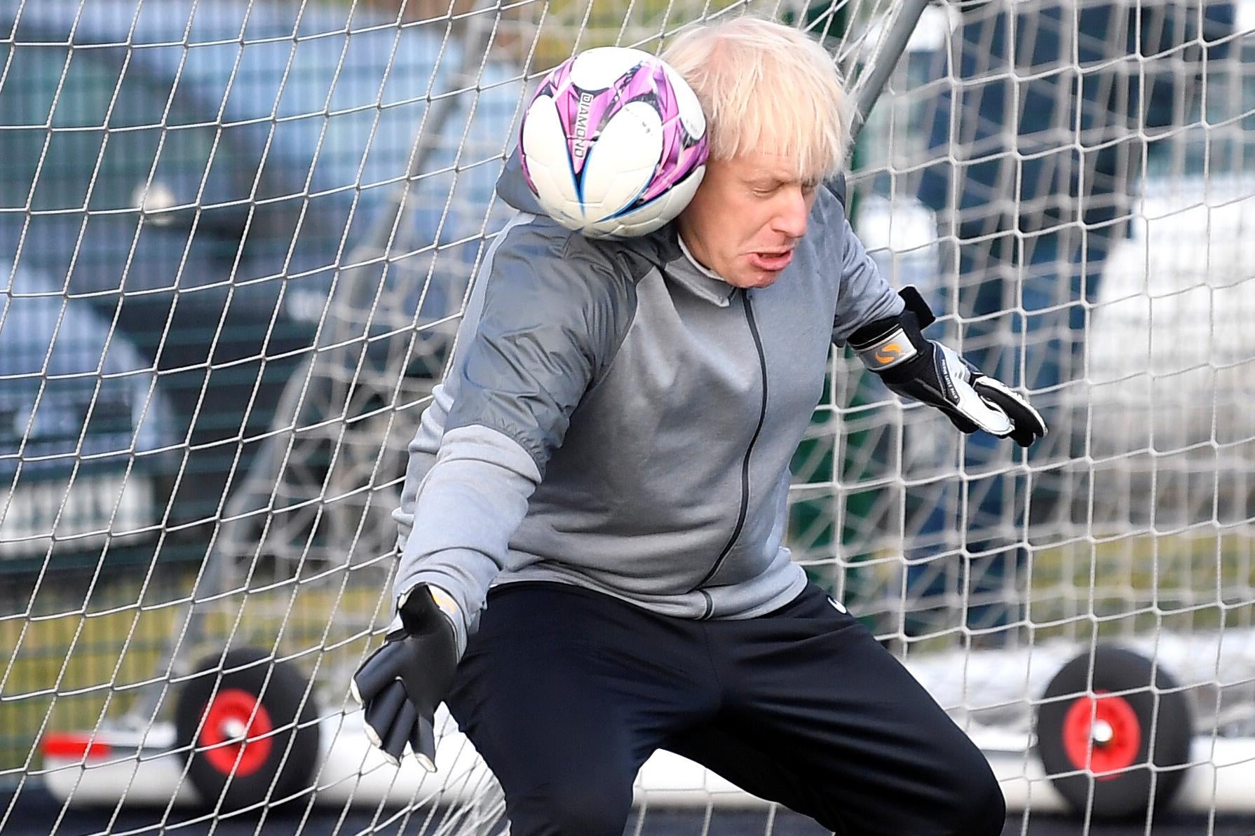Boris Johnson gets hit in the head with a soccer ball while goalkeeping.