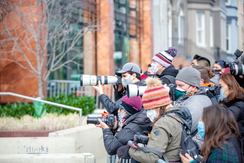 Photographers and reporters stand outside a church